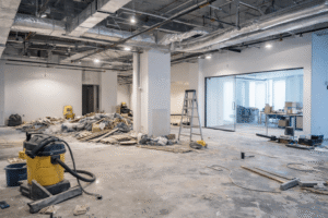Post-construction cleaning inside a commercial building with debris removal and floor preparation before final inspection.